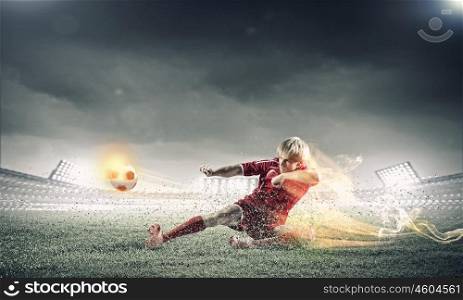 Football player. Young football player on stadium kicking ball