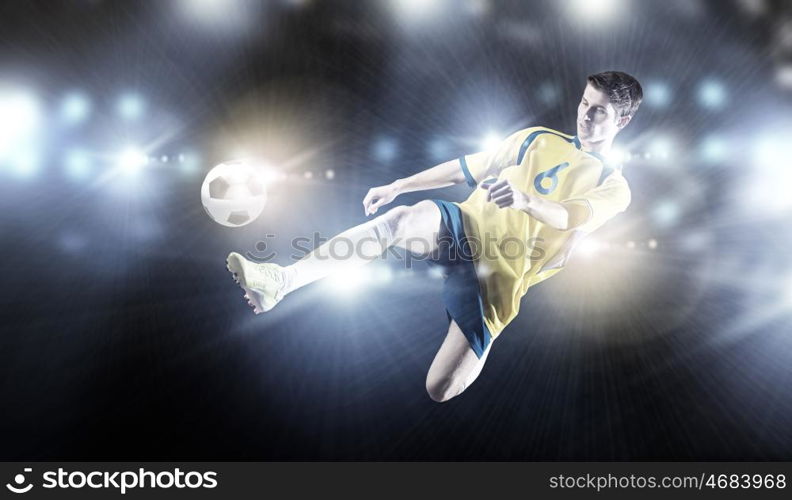 Football player. Young football player on stadium kicking ball