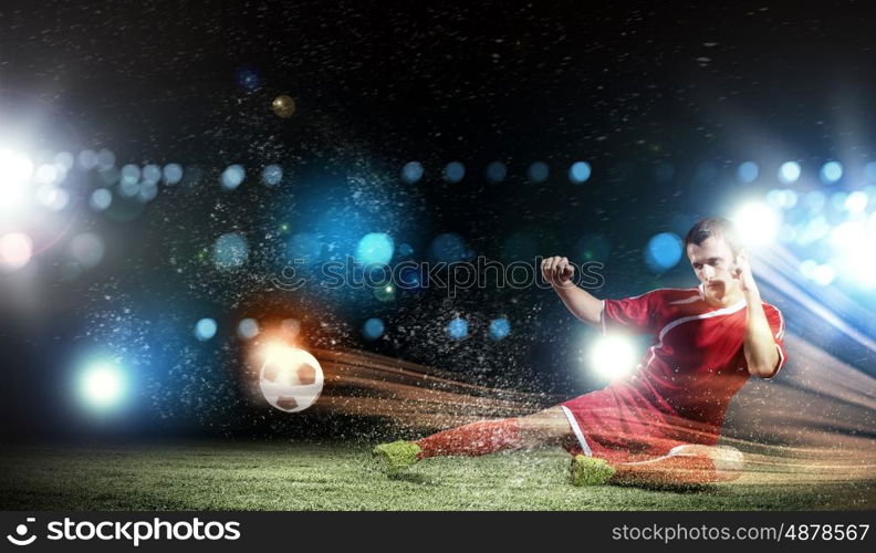 Football player. Young football player on stadium kicking ball