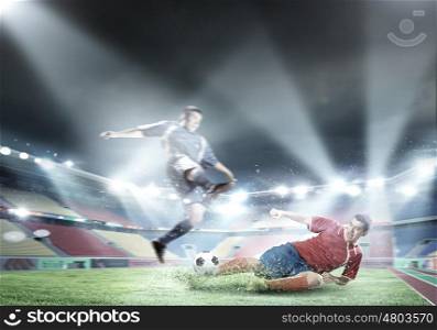 Football players. Two football player fighting for ball at stadium