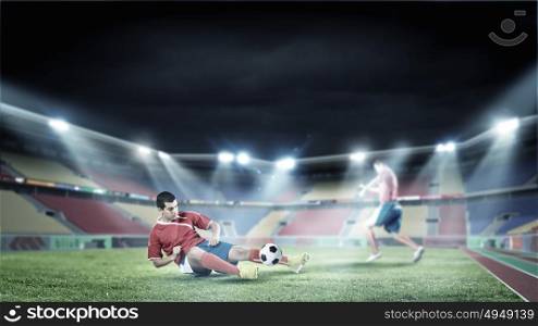 Football players. Two football player fighting for ball at stadium