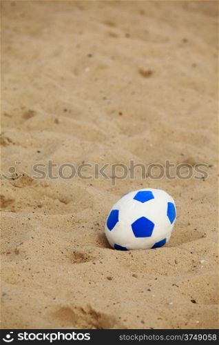 Football soccer ball on sandy beach background