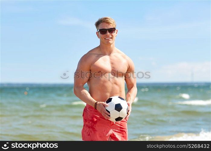 football, sport, fitness and people concept - young man with soccer ball on summer beach. young man with soccer ball on beach
