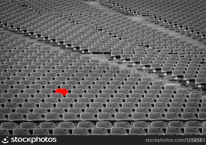 Football stadium with empty seats. Outstanding empty red plastic chair at soccer arena. Row of unoccupied bench at sports stadium. Reserved seating for football game concept. Outdoor audience chairs.