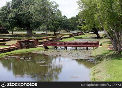 Footbridge on the lake and ruins in Sukhotai, Thailand