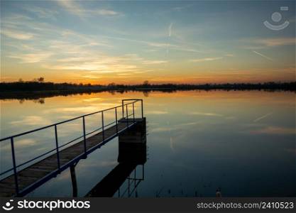 Footbridge on the lake and the view after sunset, Staw, Lubelskie, Poland