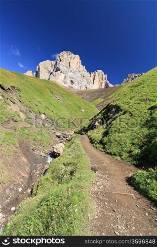 footpath beneath Sassolungo Mount on summer, Trentino, Italy