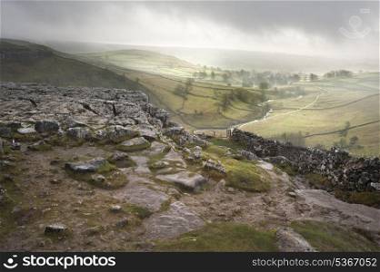 Footpath from limestone pavement down to Malham Cove in Yorkshire Dales National Park during Autumn sunrise