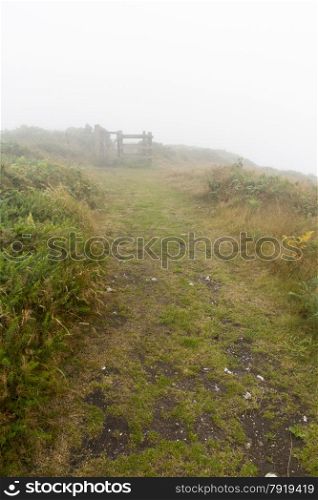 Footpath in the mist. Abbotsbury Castle, Dorset, England, United Kingdom.