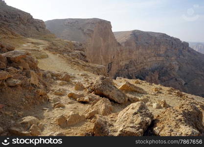 Footpath on the edge of crater Makhtesh Katan in Negev desert, Israel
