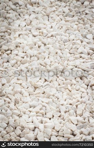 Footpath or sidewalk made of small white stones, background texture. Footpath made of small white stones, background texture
