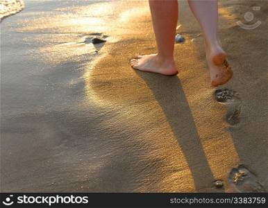 footprint on sand. Sunset illumination, a fragment of female feet