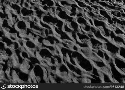 footprints in the black sand