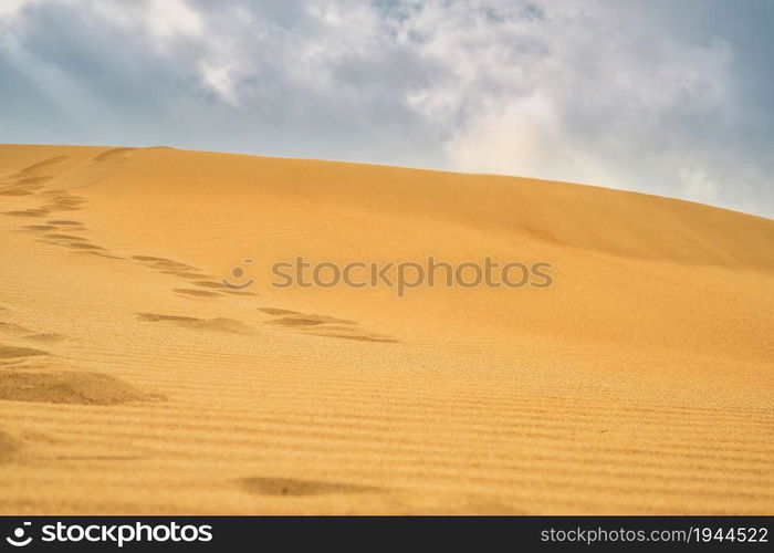 Footprints in the sand on a sand dune on the Black Sea coast. Selective focus in the middle ground on the sand. Dunes against the sky, summer idea banner