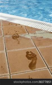 Footprints of bare feet to swimming pool. Water footprints