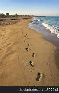 Footprints on beach background. A footprint of human feet on the sand near the sea