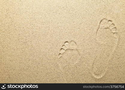 Footprints on sandy beach background with copy space