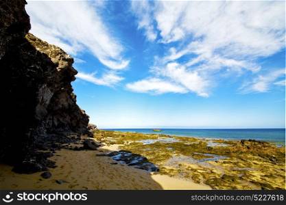 footstep coast people stone volcanic spain water in lanzarote sky cloud beach and summer