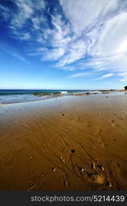 footstep in lanzarote spain rock stone sky cloud beach water musk pond coastline and summer