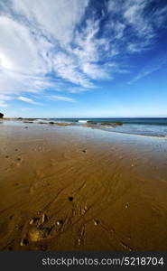 footstep in lanzarote spain rock stone sky cloud beach water musk pond coastline and summer