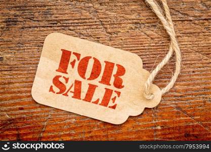 for sale sign a paper price tag against rustic red painted barn wood - shopping concept