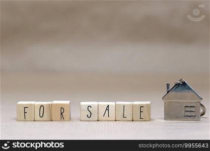 For sale written with wooden cubes, new house, real estate concept background, close up and copy space. For sale written with wooden cubes, new house, real estate concept background,
