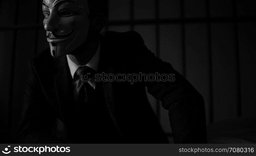 Foreboding shot of Anonymous hacker man in prison (B/W Version)
