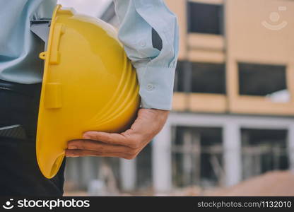 Foreman construction project control holding hard hat safety at estate building