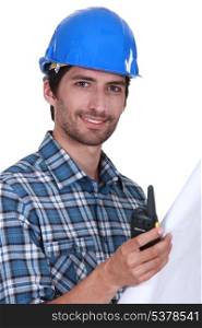 Foreman holding radio and plans