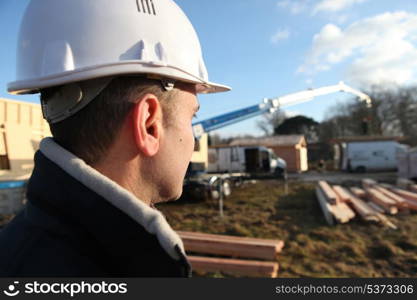 foreman in construction site with back turned to camera