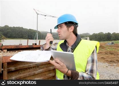 Foreman on building site with walkie-talkie