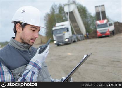 foreman using walkie-talkie on construction site