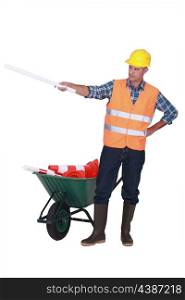 Foreman with plans and a barrow of traffic cones