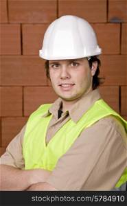 foreman with white hat with a brick wall as background