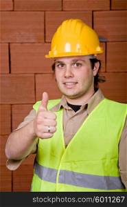foreman with yellow hat and a brick wall as background