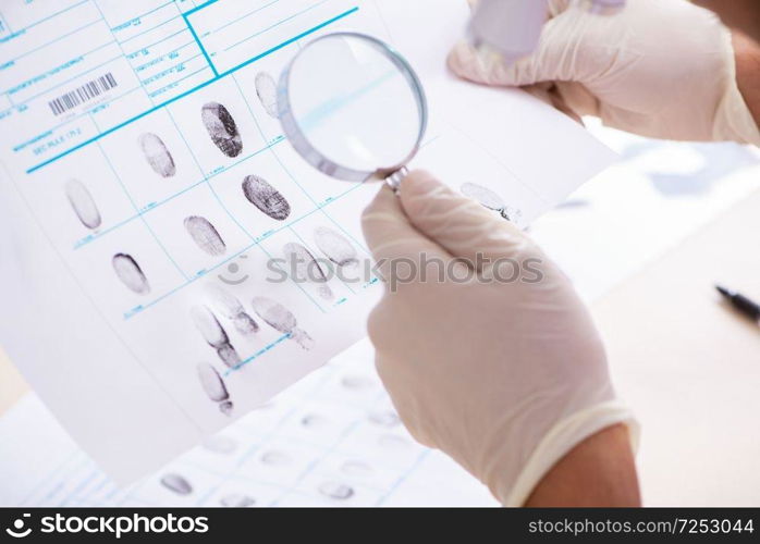 Forensic expert studying fingerprints in the lab