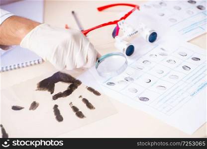 Forensic expert studying fingerprints in the lab