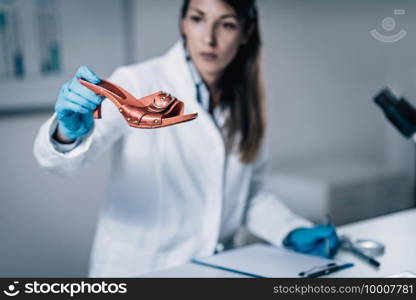 Forensic Science in Lab. Forensic Scientist examining shoe with evidences