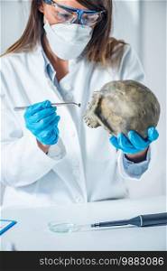 Forensic scientist examining human skull