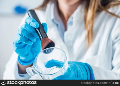 Forensic scientist in a lab, looking for fingerprints