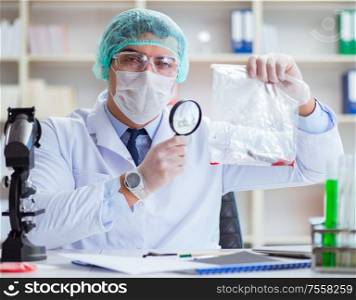 Forensics investigator working in lab on crime evidence. The forensics investigator working in lab on crime evidence