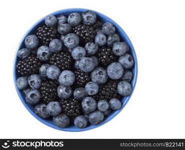 Forest berries (blueberry,bramble) in a ceramic blue bowl. Top view.