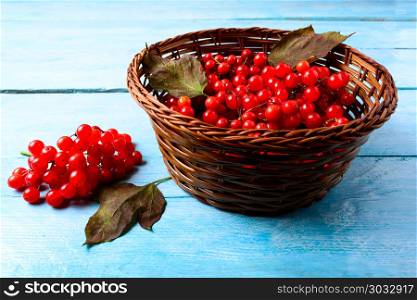 Forest berries in wicker basket on blue wooden table. Forest berries in wicker basket on blue wooden table. Wild ripe berries in basket.