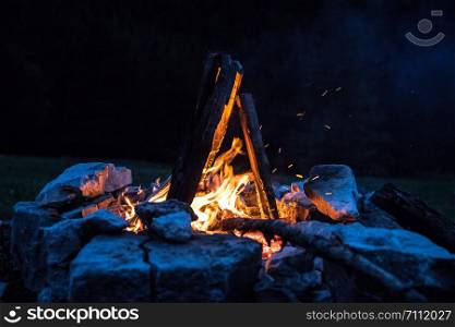 Forest bonfire in the summer, camping time with friends. Copy space.