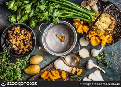 Forest Mushrooms cooking preparation on rustic kitchen table with empty cooking pot and vegetables, top view. Autumn cooking concept
