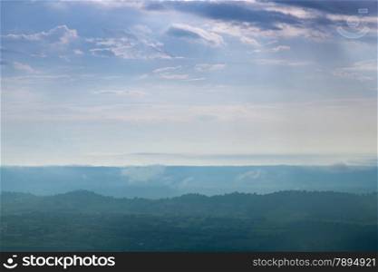 Forested mountains and sky. A slight mist-shrouded mountains and trees. Clear sky