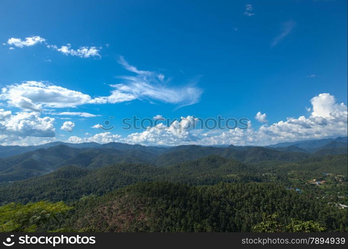 Forested mountains and sky. Luxuriant trees of the forest-covered mountains. The sky is clearing up.