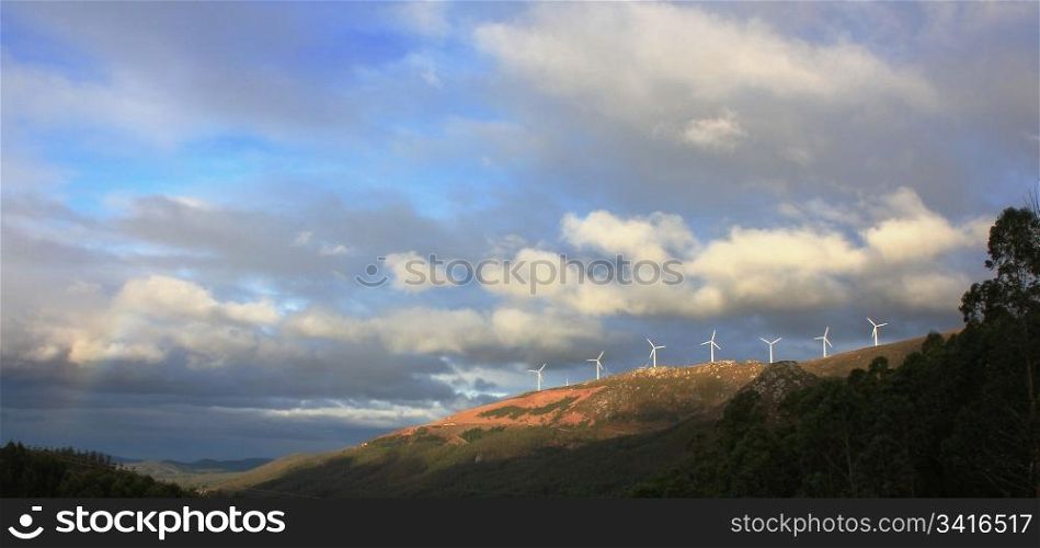 forested mountains with clouds and windmills eolian