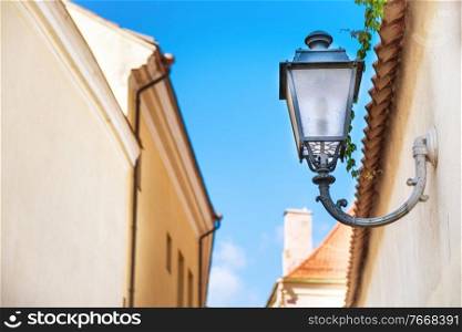 Forged metal streetlight at old european street with blue sky