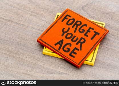 Forget your age advice or reminder - handwriting on a sticky note against grained wood